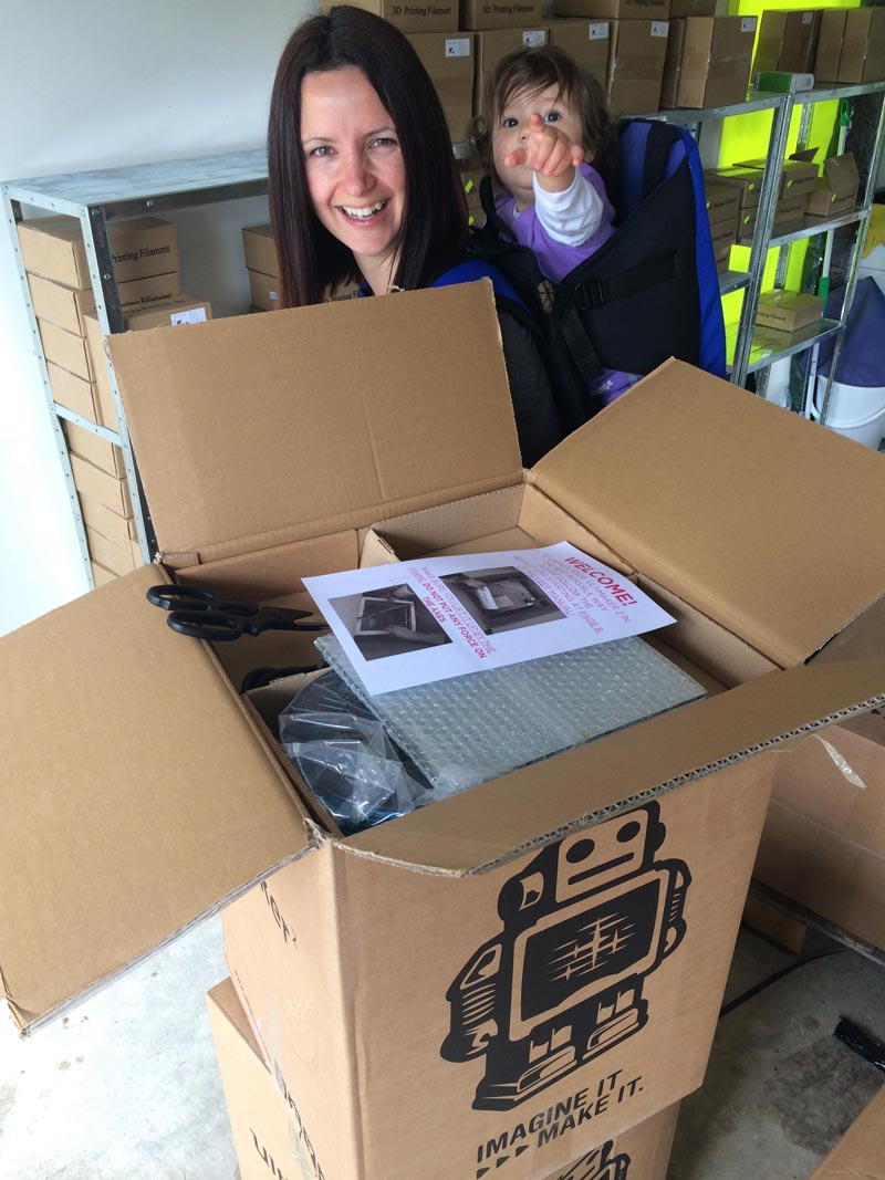 Fay with daughter on back while packing box